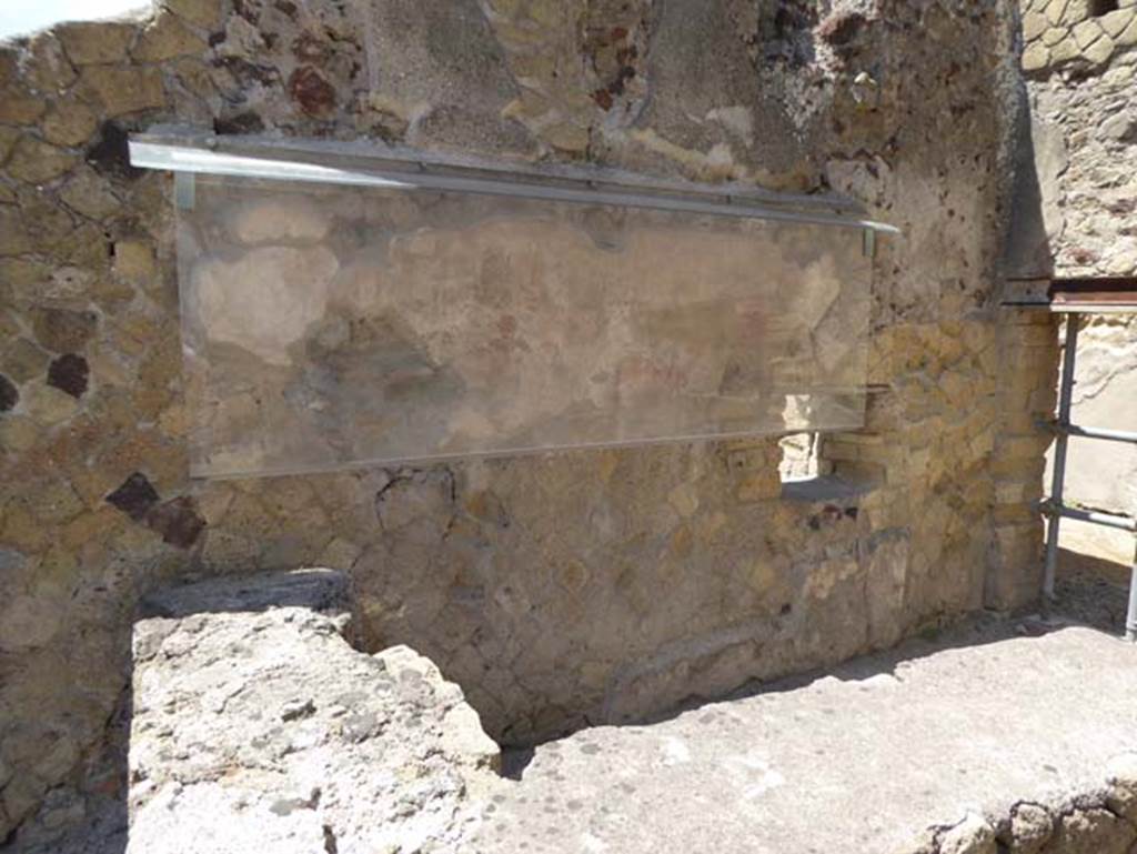 IV.17, Herculaneum, July 2015. Looking south towards the remains of the Priapus figure painted on the wall behind the sales counter. Photo courtesy of Michael Binns.